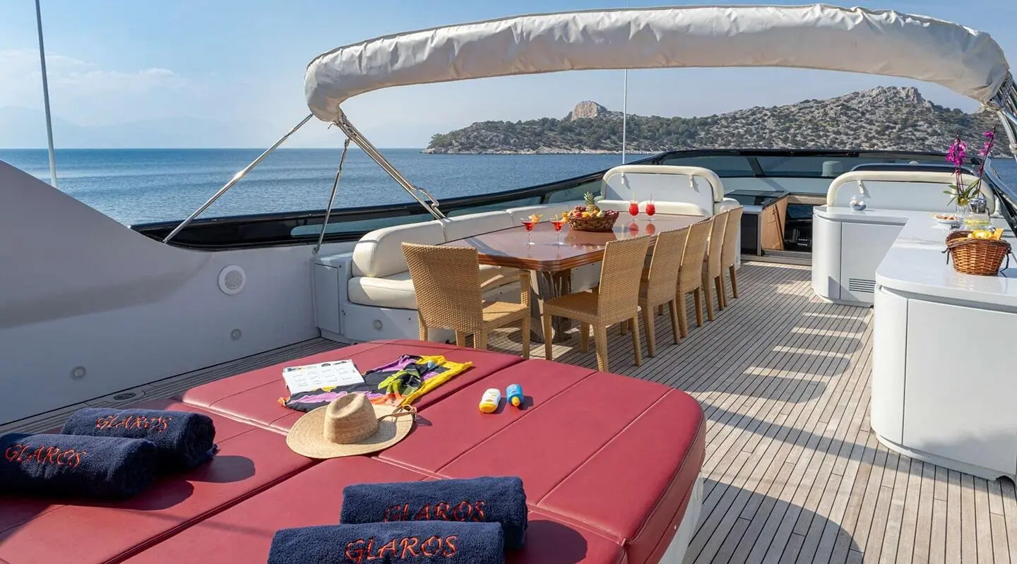 Glaros yacht deck with table, chairs, and sun loungers on a sunny day