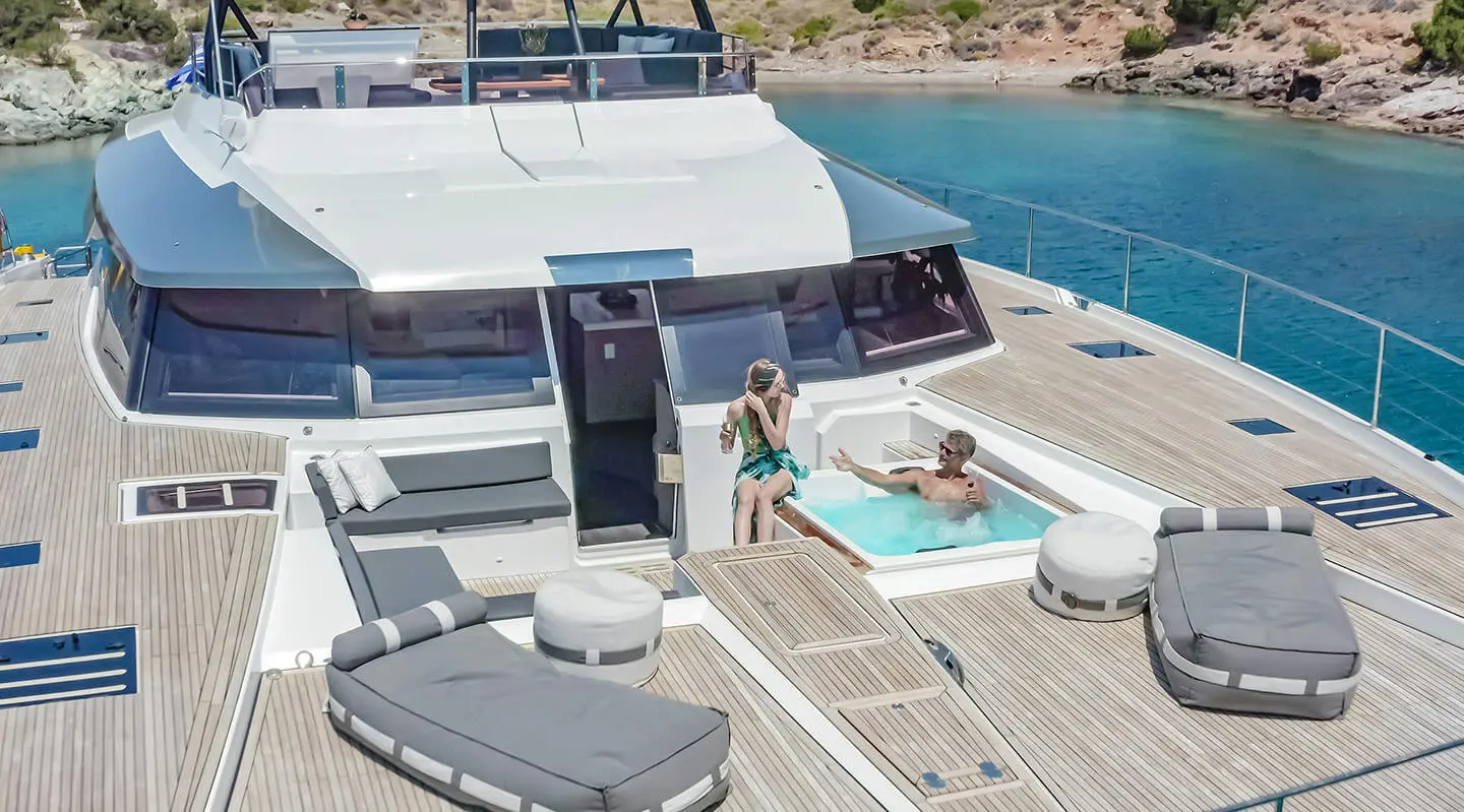 Deck view of D2 luxury yacht with people relaxing on sun loungers and seating