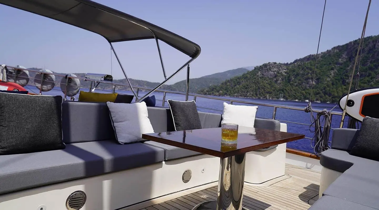 Queen Of Makri yacht on calm sea at sunset with shaded seating area
