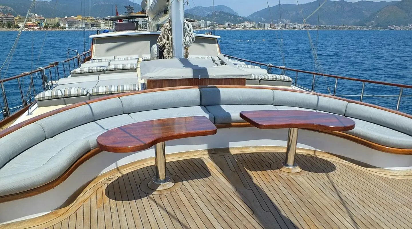 Sunset view from a luxury gulet deck with cushioned seating and polished wood