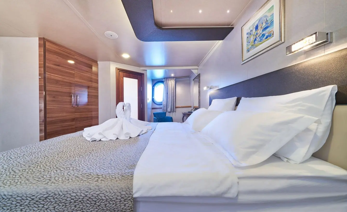 Interior of Casablanca yacht cabin with two beds, wooden accents, and blue ambient lighting
