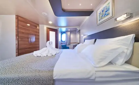 Interior of Casablanca yacht cabin with two beds, wooden accents, and blue ambient lighting