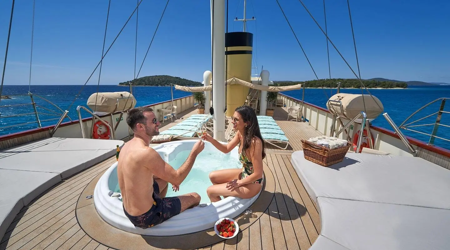 Casablanca yacht deck scene with two people seated and city skyline in background