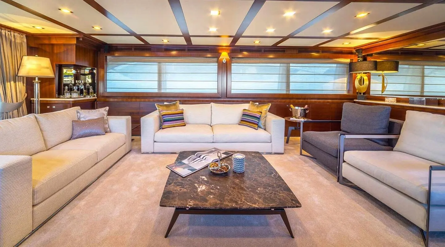 Seventh Sense luxury yacht salon at sunset with plush seating and marble coffee table