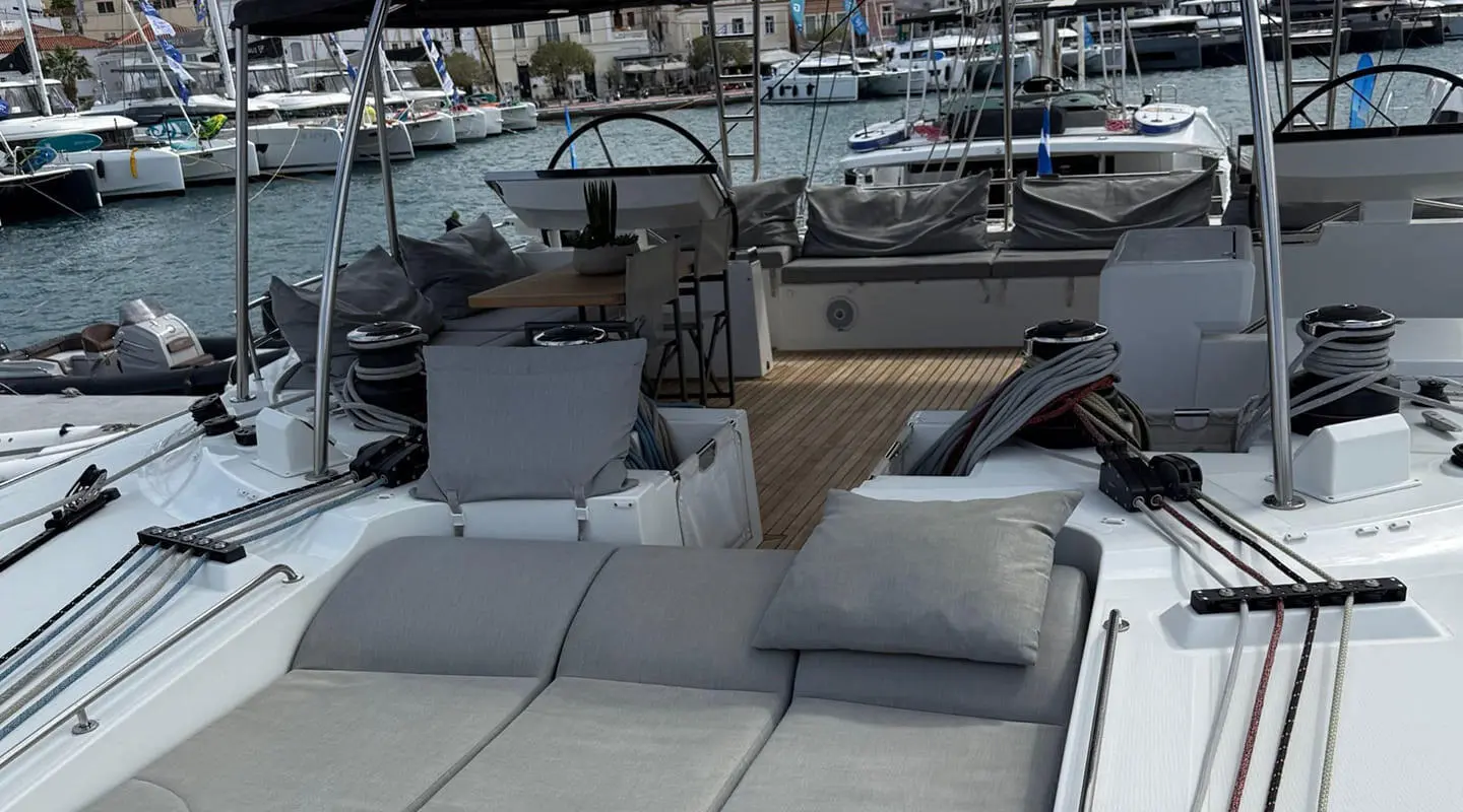 Atlantis yacht deck with white loungers, cushions, and a marinas backdrop at sunset