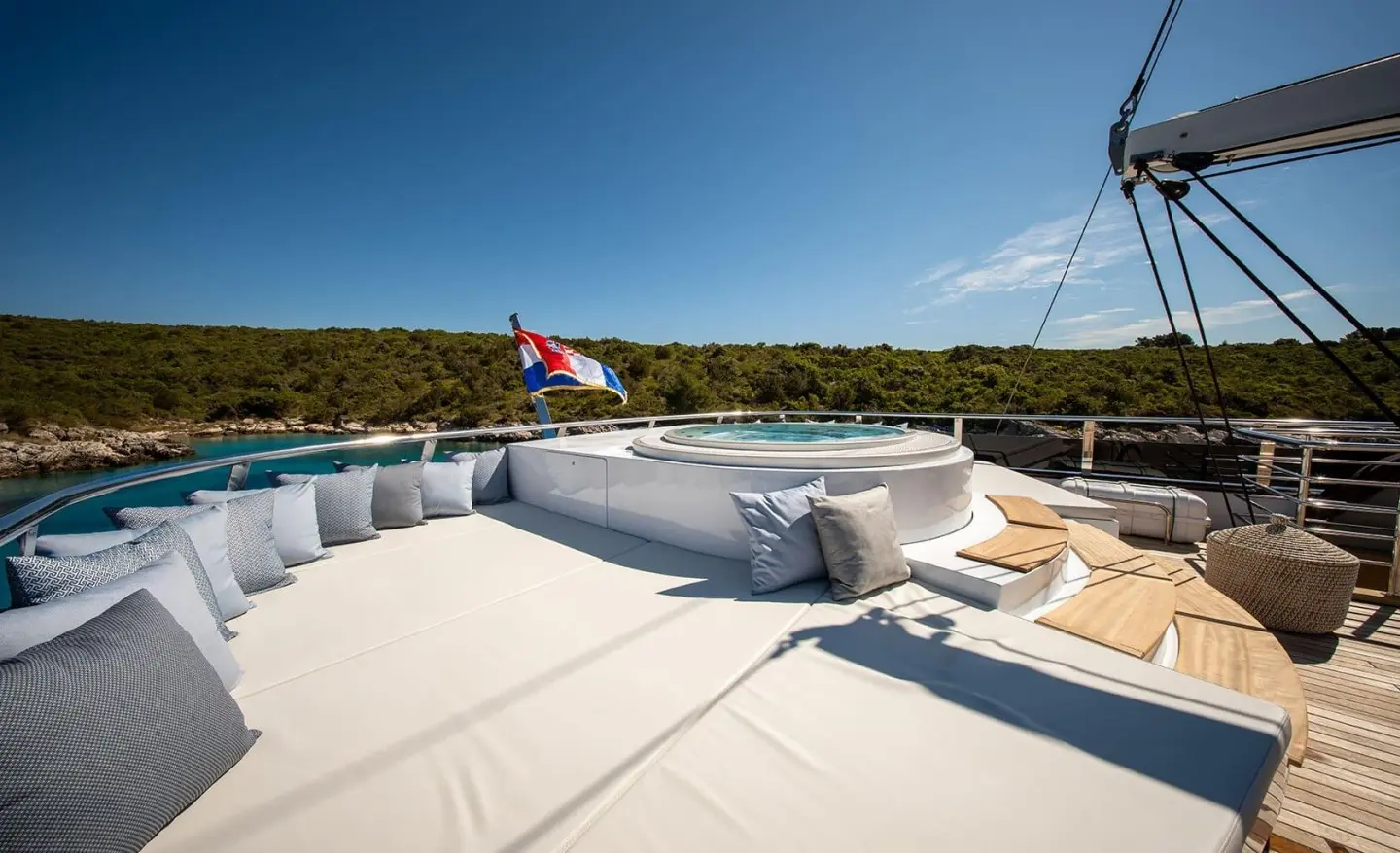 Anima Maris yacht deck with white seating and a jacuzzi area on sunny day