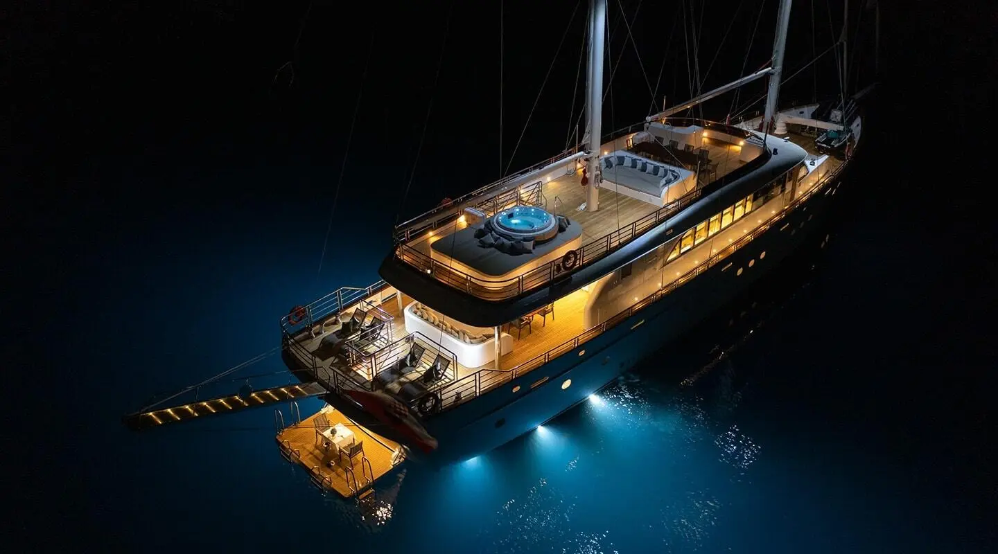 Love Story gulet at night with illuminated deck floating on dark water