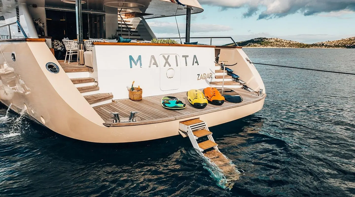 Maxita yacht named deck area with stairs, swim platform, and water nearby