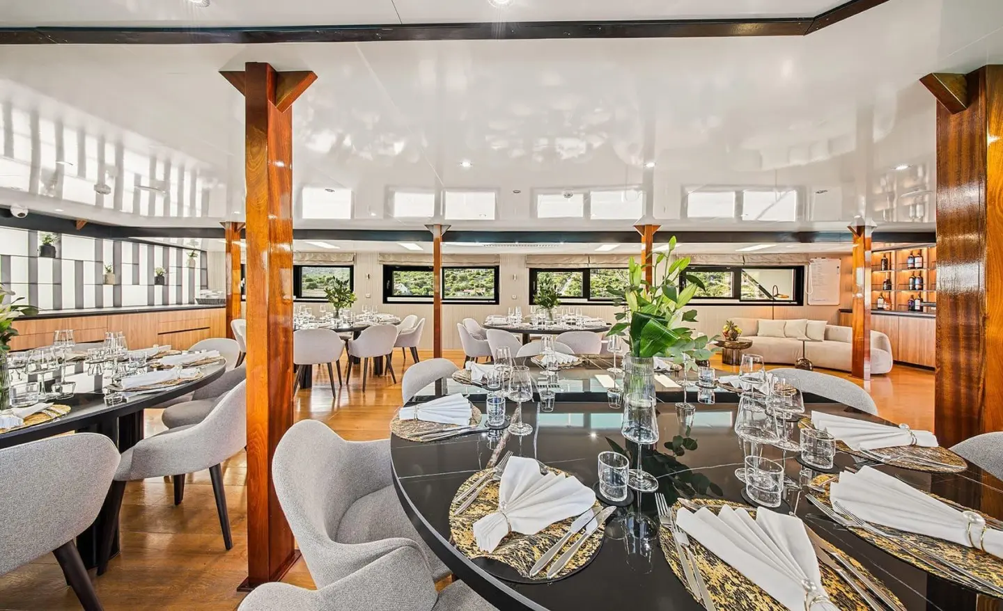 Karizma yacht interior dining hall with wooden columns and set tables