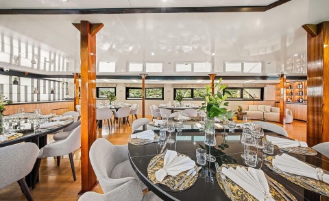 Karizma yacht interior dining hall with wooden columns and set tables