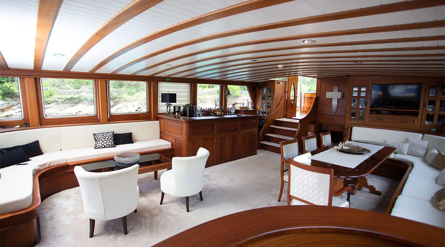 Interior of Dolce Vita gulet with curved wooden beams, white seating, and windows