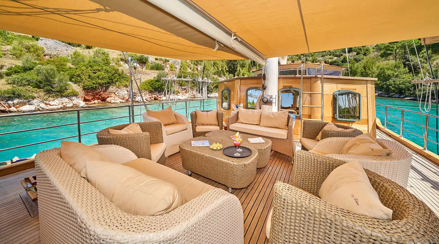 Libra luxury gulet at sunset, sunlit deck seating and teak railings