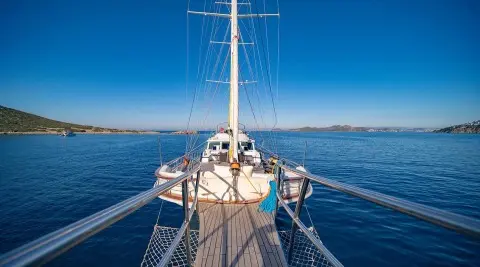 View from the bow of a luxury yacht at sea, rigging and deck ahead