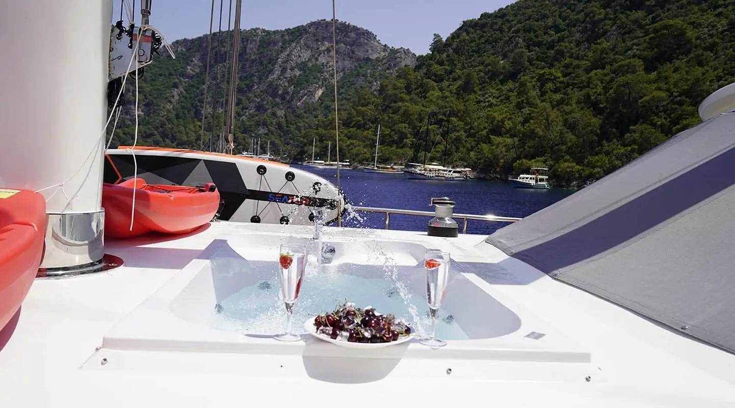 View of the Queen Of Makri gulet deck with jacuzzi and wine glasses aboard