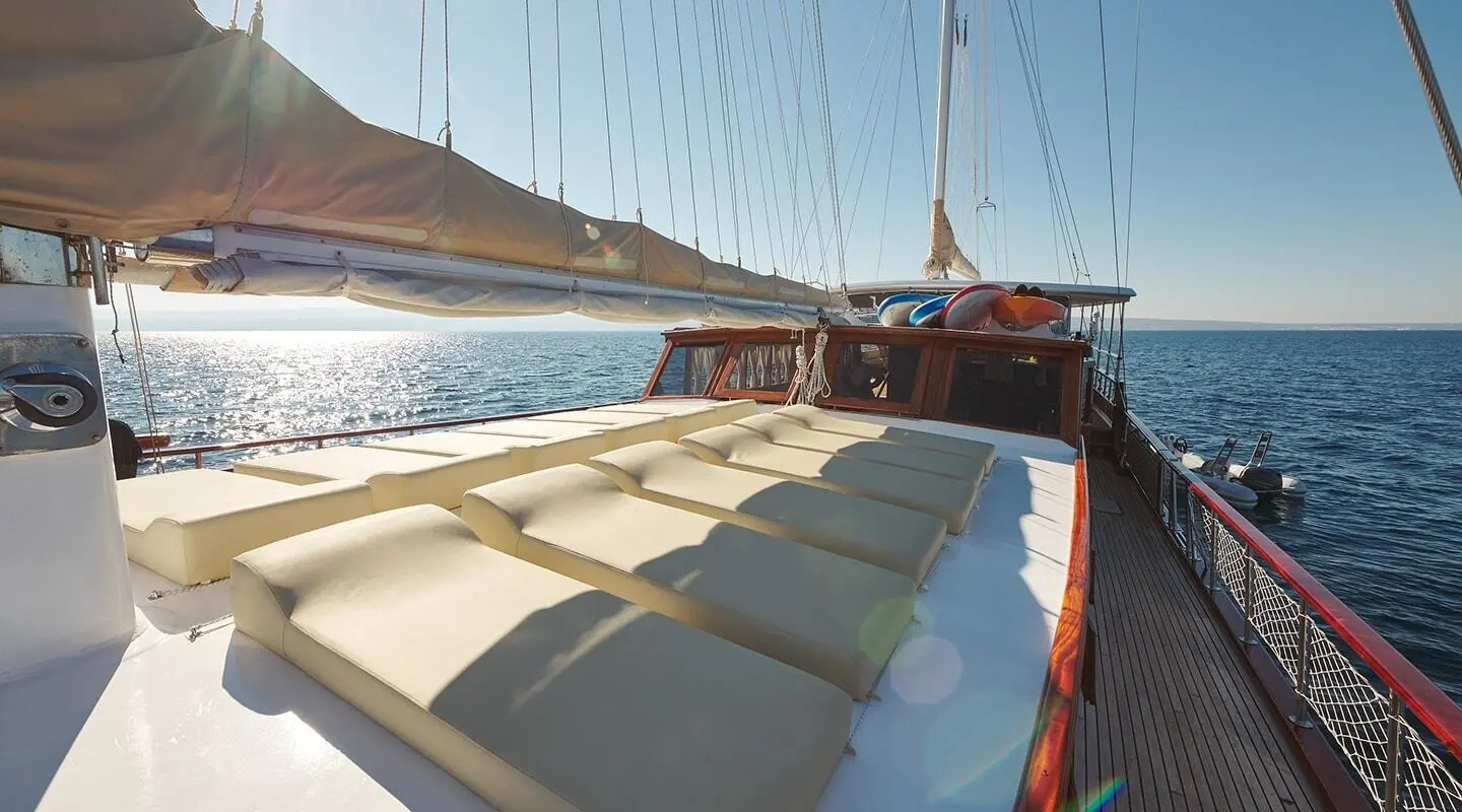 Linda yacht charter: cushioned seating on deck with rigging and sunset