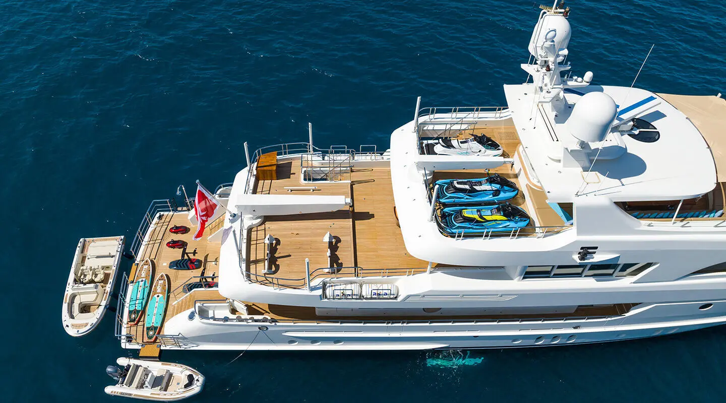 Serenity yacht docked beside another vessel, with passengers on the upper deck