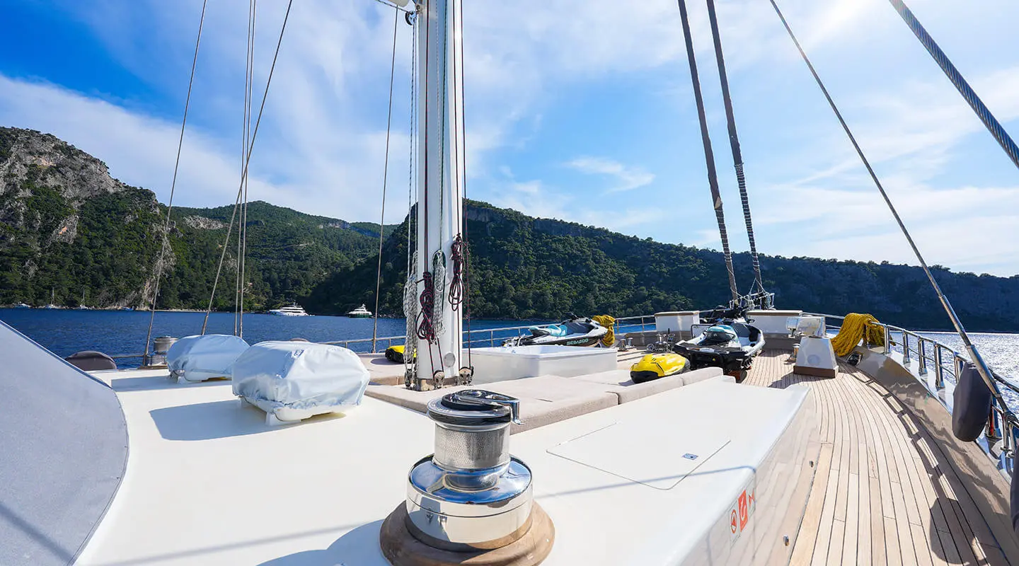 Bowsprit area on King Of The Sea yacht with rigging and calm harbor behind