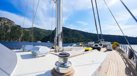 Bowsprit area on King Of The Sea yacht with rigging and calm harbor behind