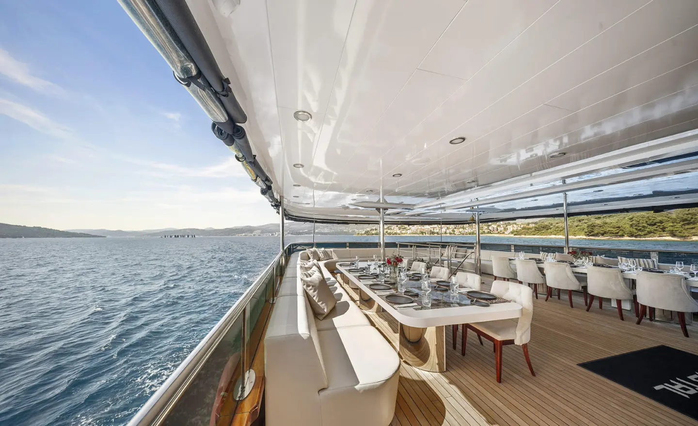 Yacht Cristal dining deck with sun chairs and railing along open sea view