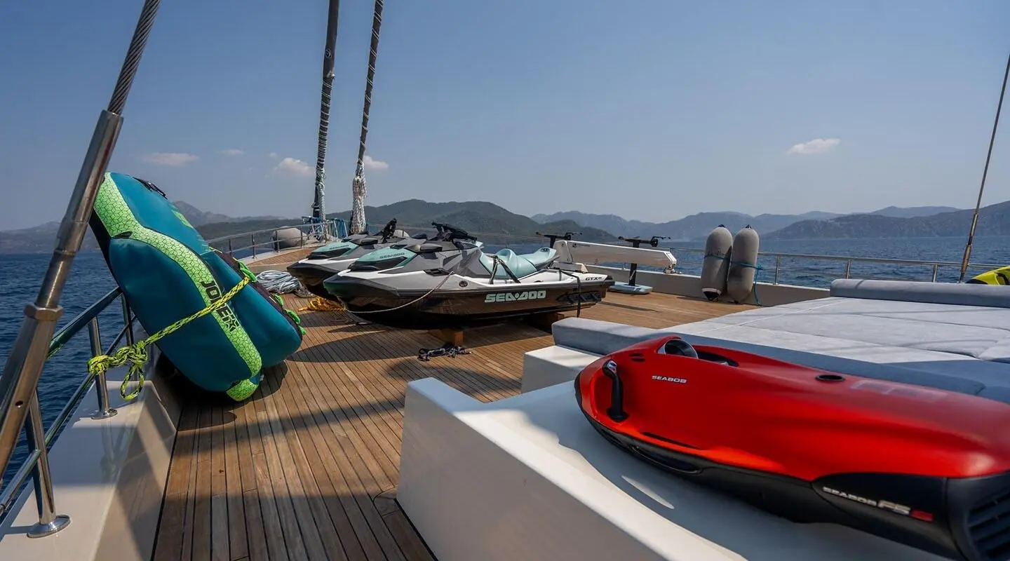 Deck of De Love yacht with lifebuoy, ropes, and masts on sunny port day