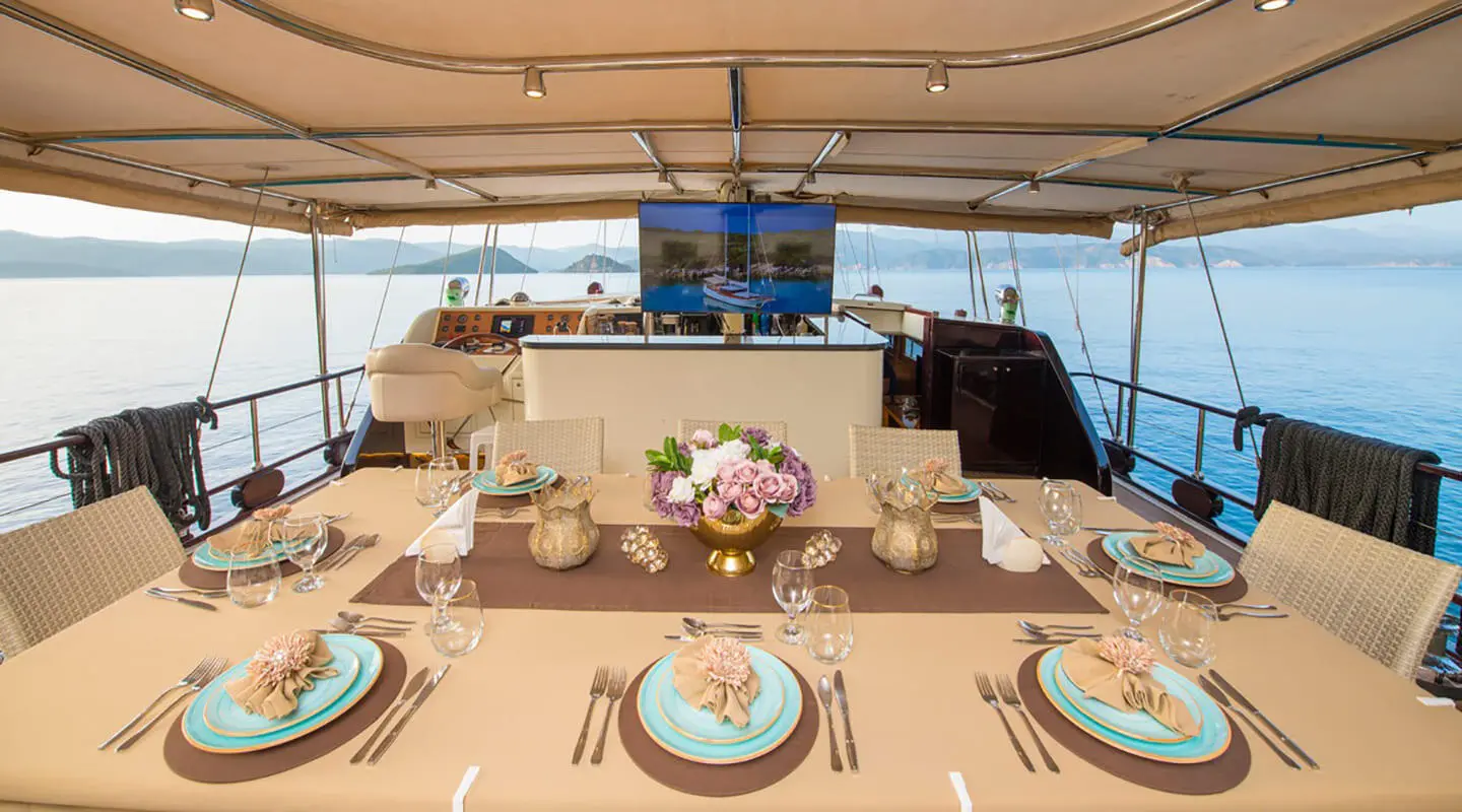 Table set for sunset dining on Mein Schatz yacht, ocean view backdrop