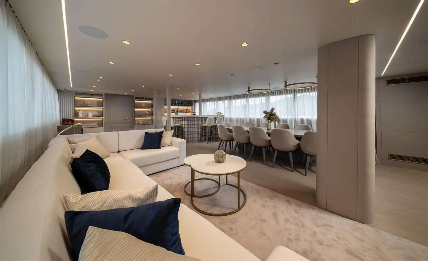 Interior of Nocturno motor yacht saloon with beige seating and large windows