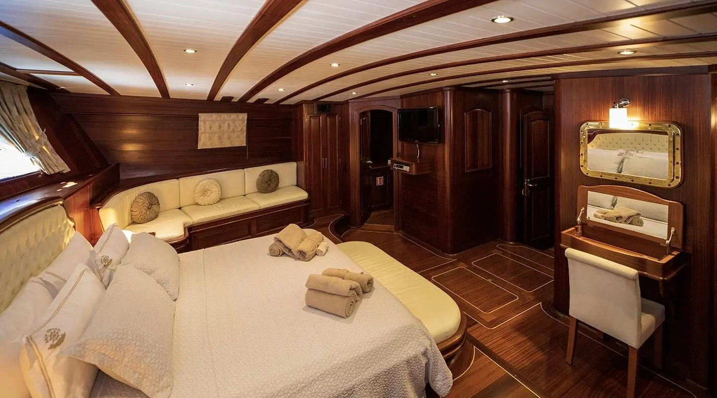 Arif Kaptan A yacht cabin interior with round bed and wooden paneling