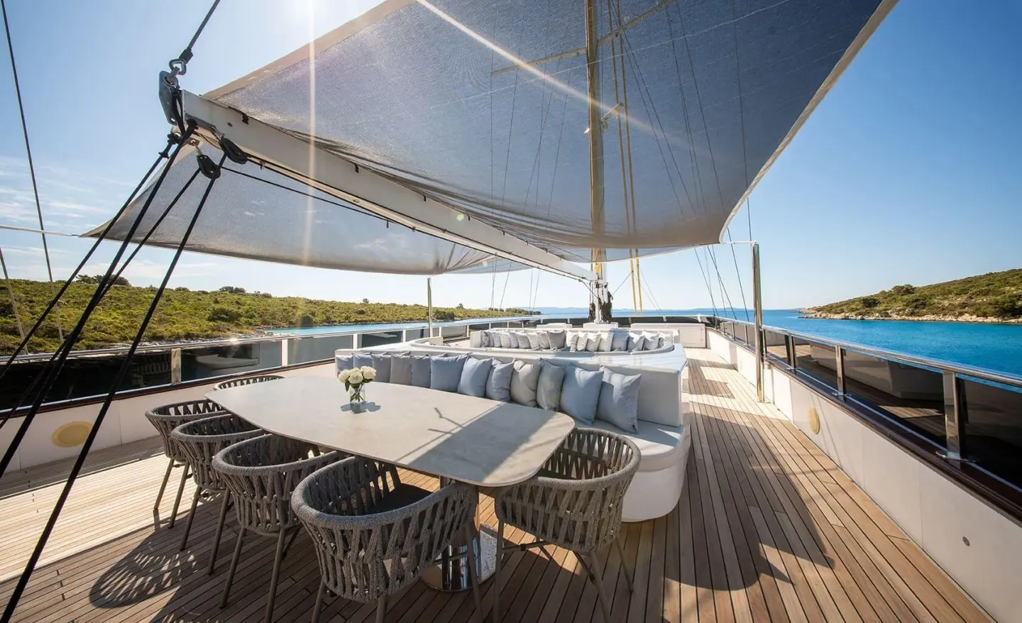 Anima Maris yacht sun deck with large table and seating under shade sail