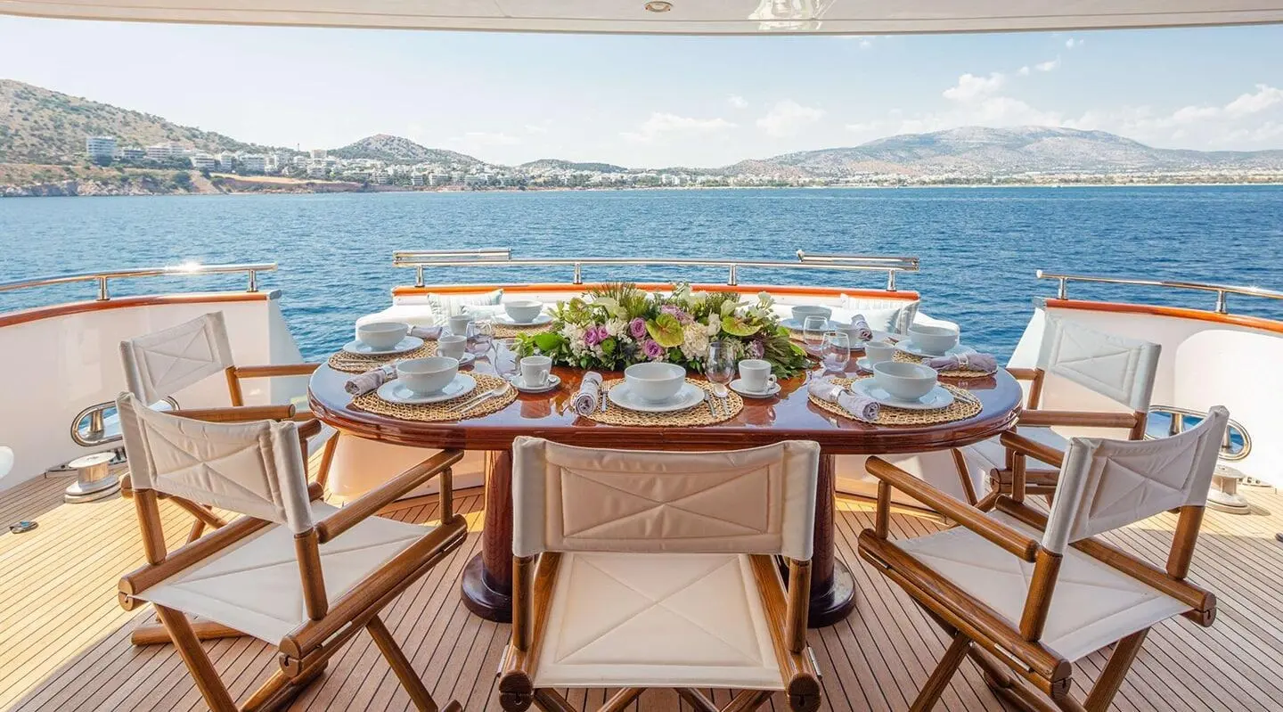 Grace yacht dining table set for sunset onboard with sea view
