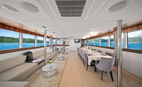 Dalmatino yacht interior: elegant salon and dining area with large windows