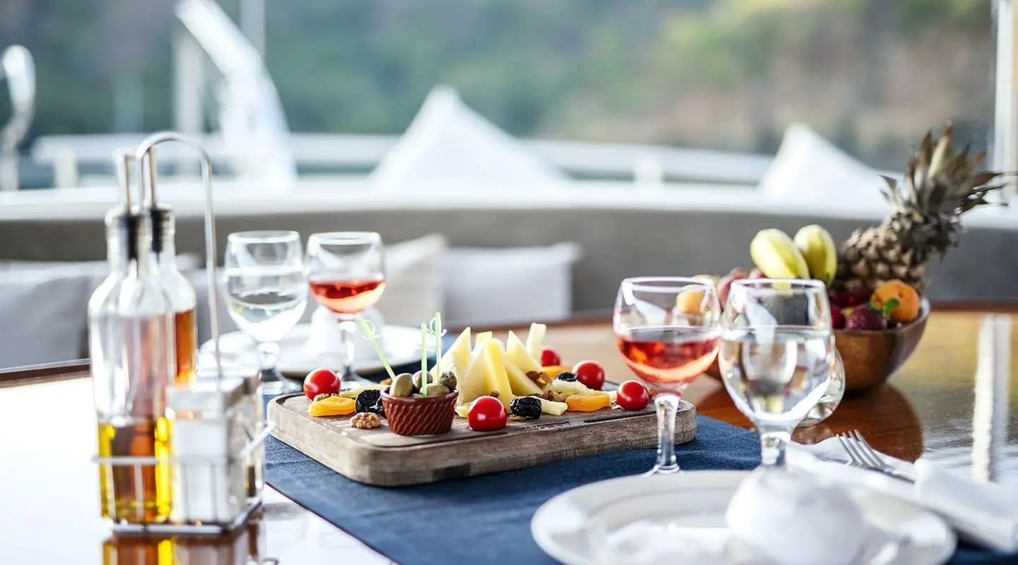 Kayhan 4 yacht at sunset with table setting and wine glasses on deck
