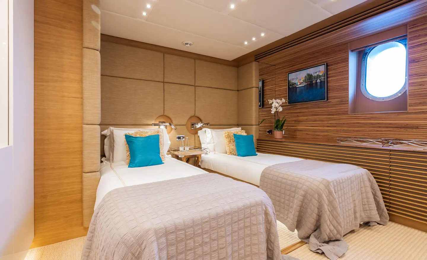 Serenity yacht twin cabin interior with two single beds and wooden accents