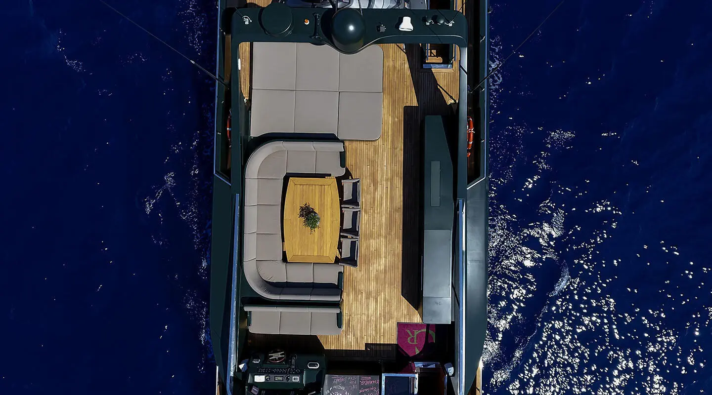 Overhead view of a luxury yacht named Can't Remember at sea, sunlit deck