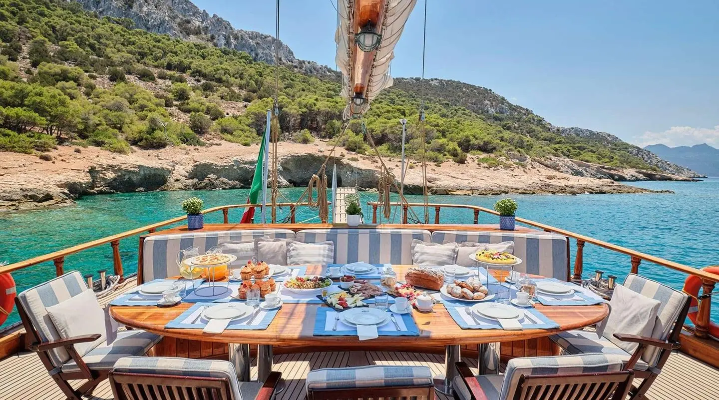 Myra luxury gulet dining setup on deck at sunset with table settings