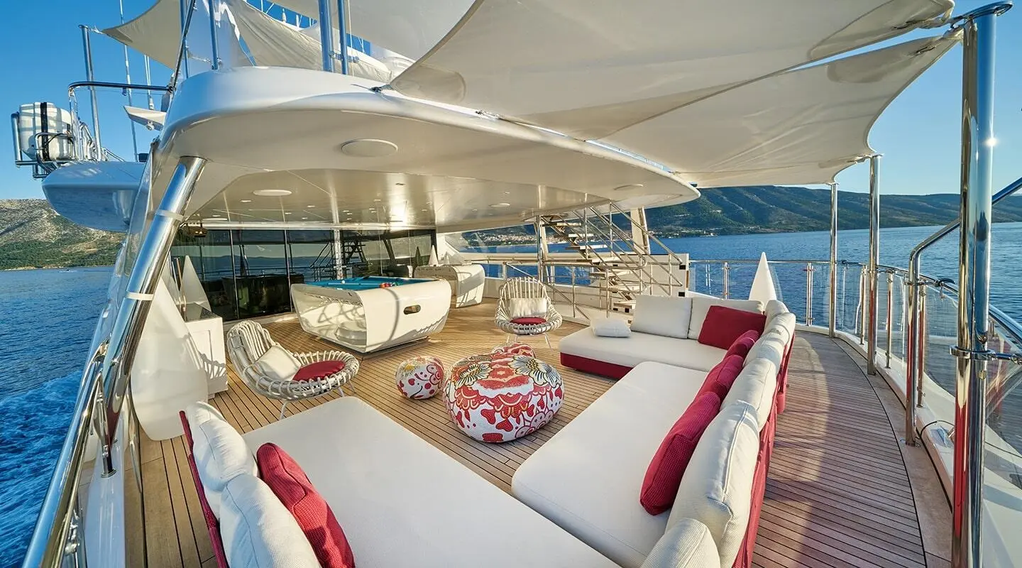 Happy Me yacht deck: sun loungers, seating, and vibrant cushions on a spacious aft area