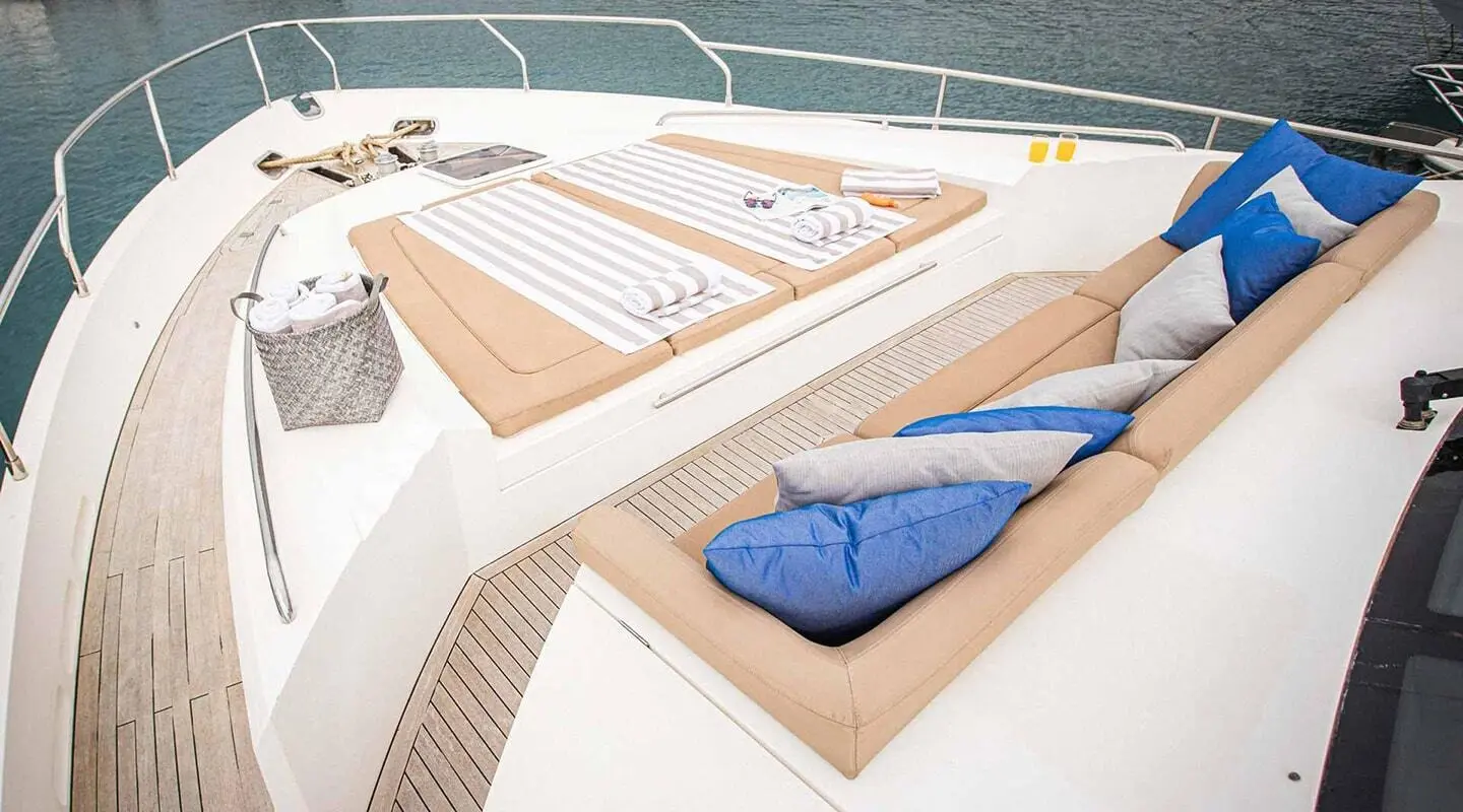 On the sundeck of Insieme yacht, two blue towels lie near sun loungers