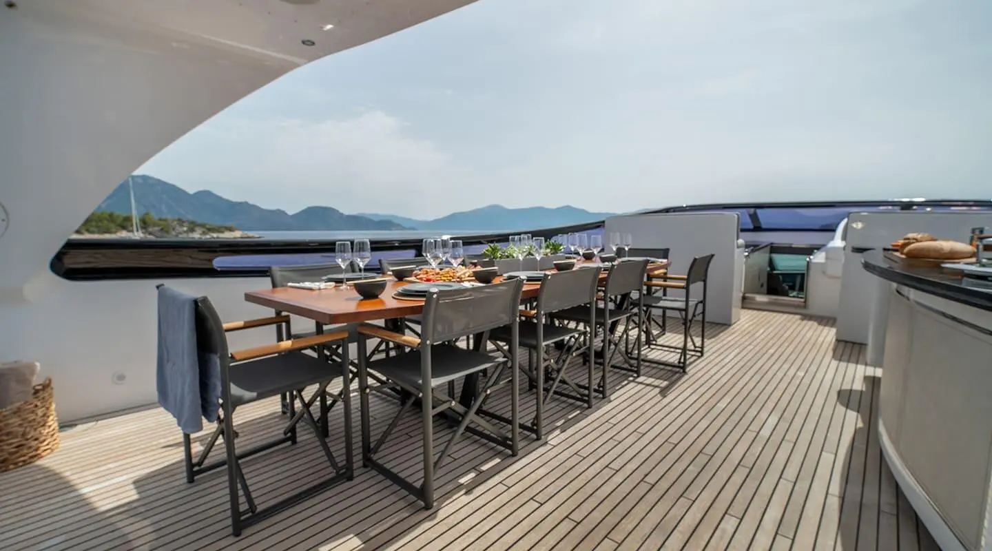 Pareaki II yacht dining area on deck with sunset views and tables