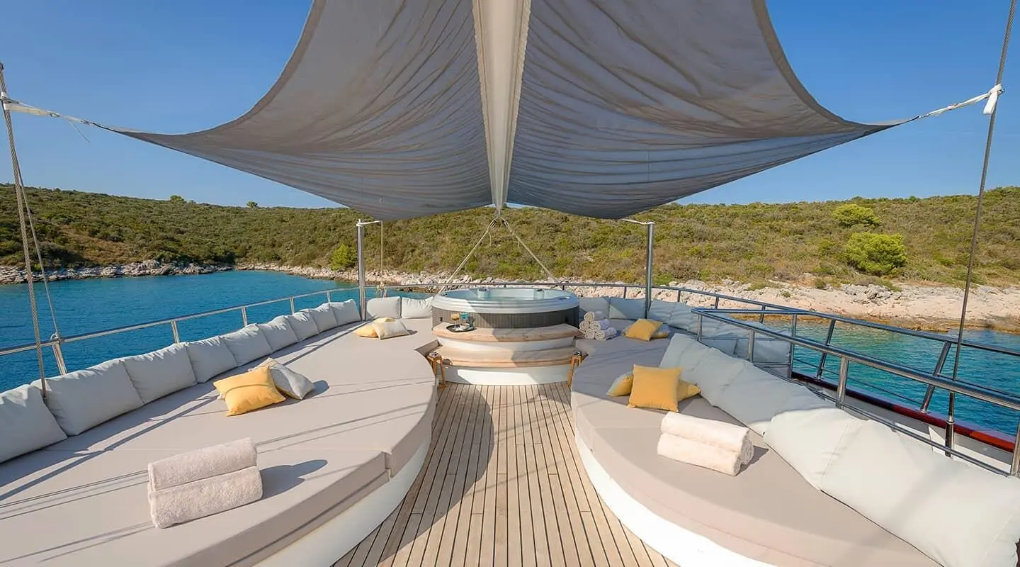Lady Gita luxury yacht charter deck with plush seating, sea view, and shaded lounge area