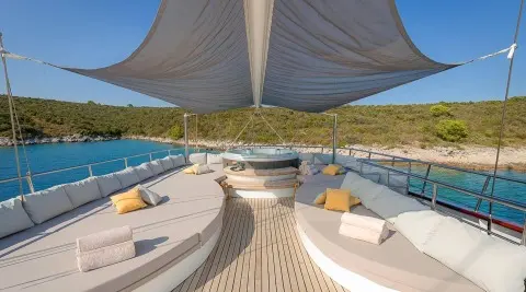 Lady Gita luxury yacht charter deck with plush seating, sea view, and shaded lounge area