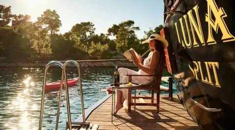 Yacht Luna stern deck with seating, ladder, and calm pool water surface