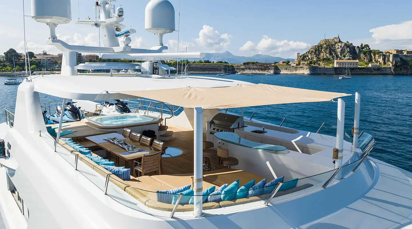 Serenity yacht sun deck with seating, blue cushions, and railing