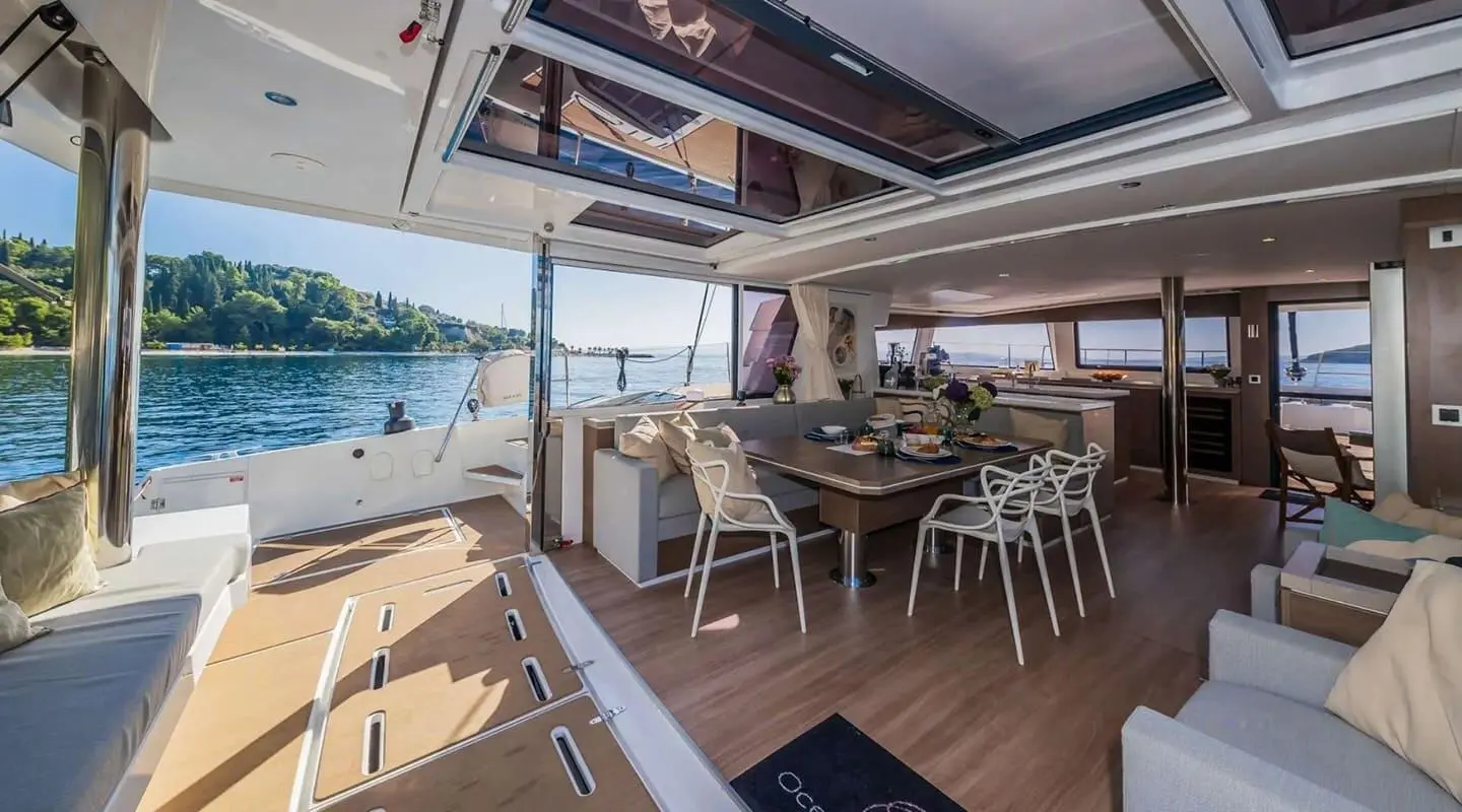 Ocean Lounge aft deck seating area with table, wooden deck, and sea view