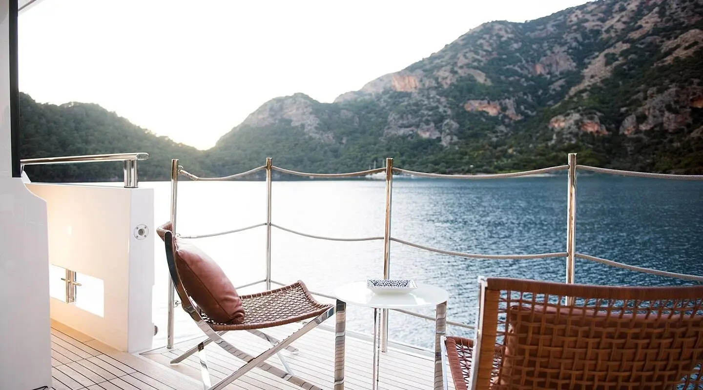 Morning Star luxury yacht docked by calm blue water with mountains in background