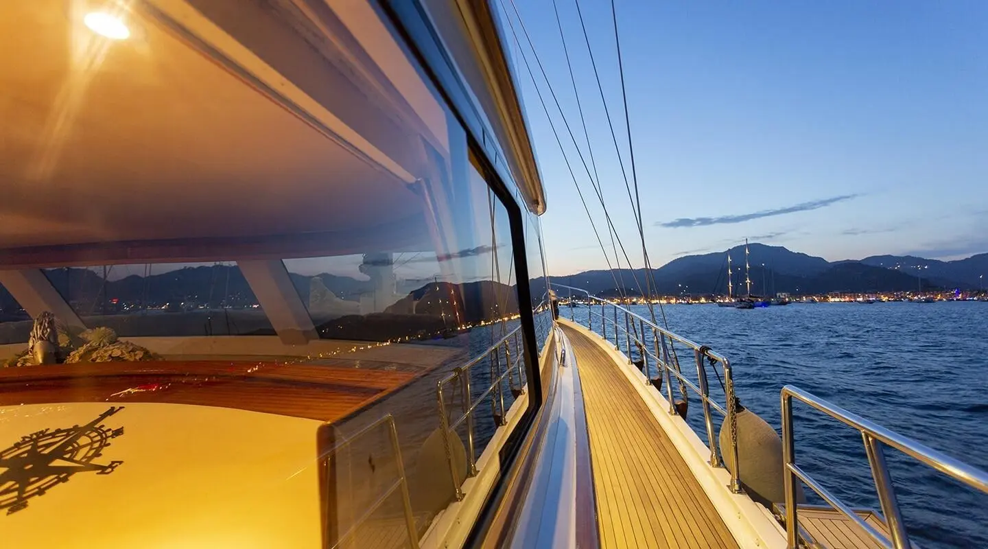 Sunlit yacht Diva Deniz deck rail and calm sea on a sailing sunset