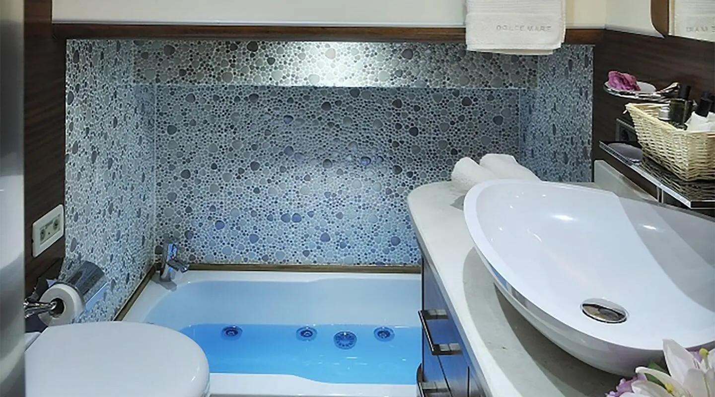Dolce Mare yacht aboard with blue tiled pool area and white seating at sunset