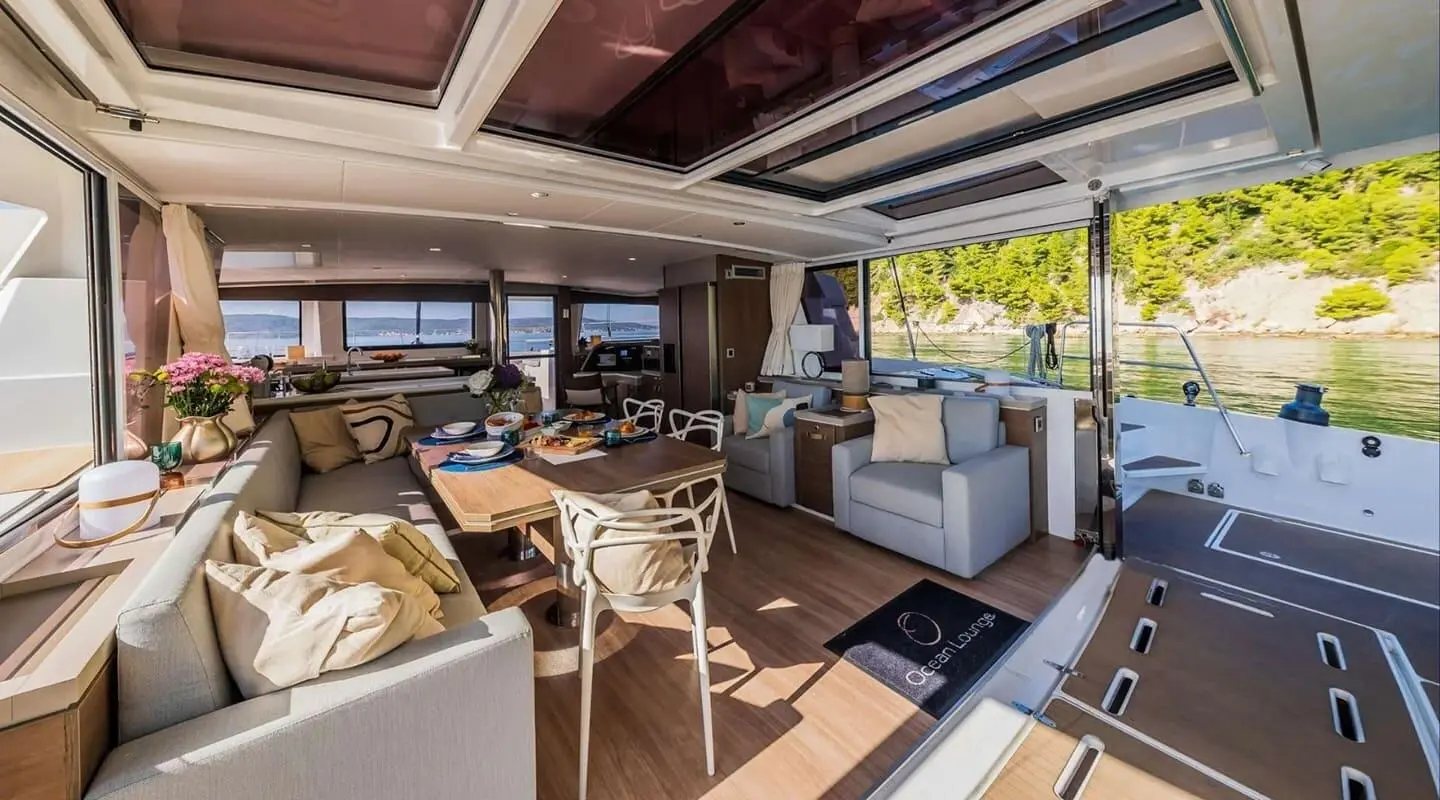Ocean Lounge yacht deck seating area with tables, cushions, and shaded lounge chairs