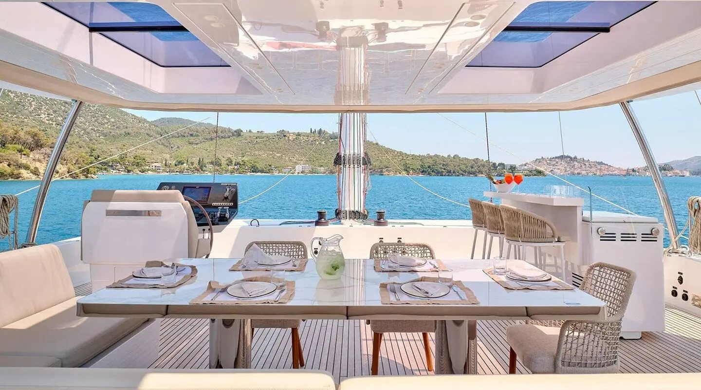 Genny luxury yacht dining area on deck with plates and glassware at sunset