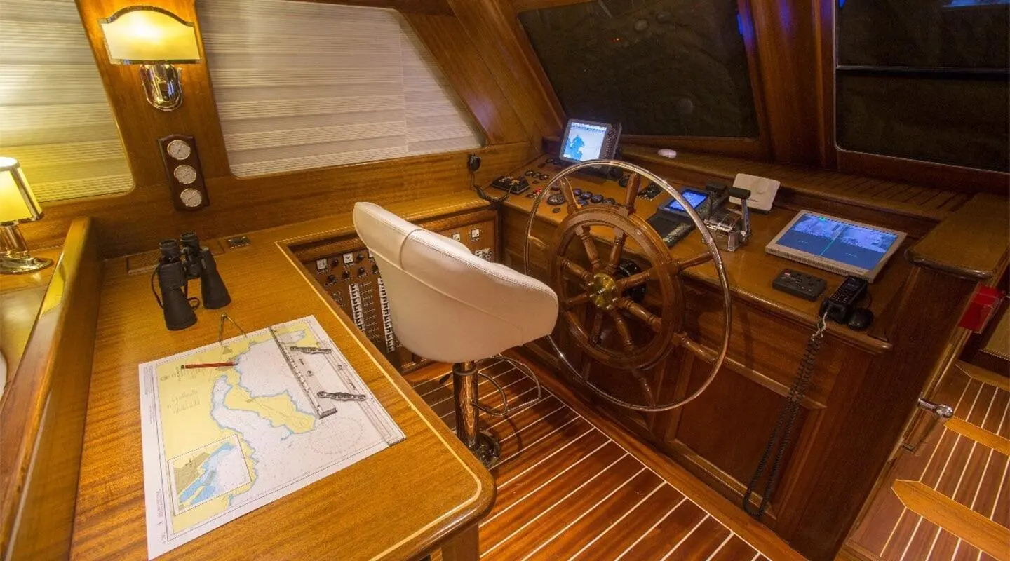 Deck area of yacht Ece Berrak featuring steering wheel and wooden helm