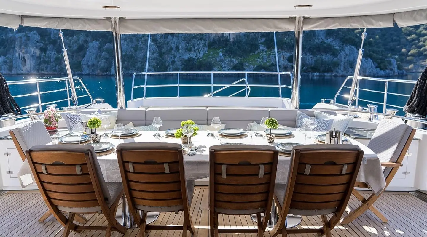 View from the deck of a luxury yacht named Long Island, sun loungers facing the sea at sunset