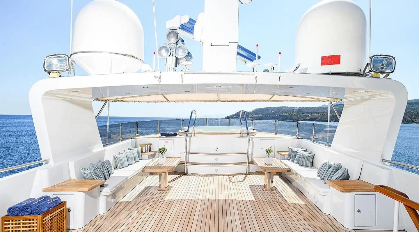 Wind Of Fortune yacht’s aft deck with white luxury seating and teak flooring, ocean view